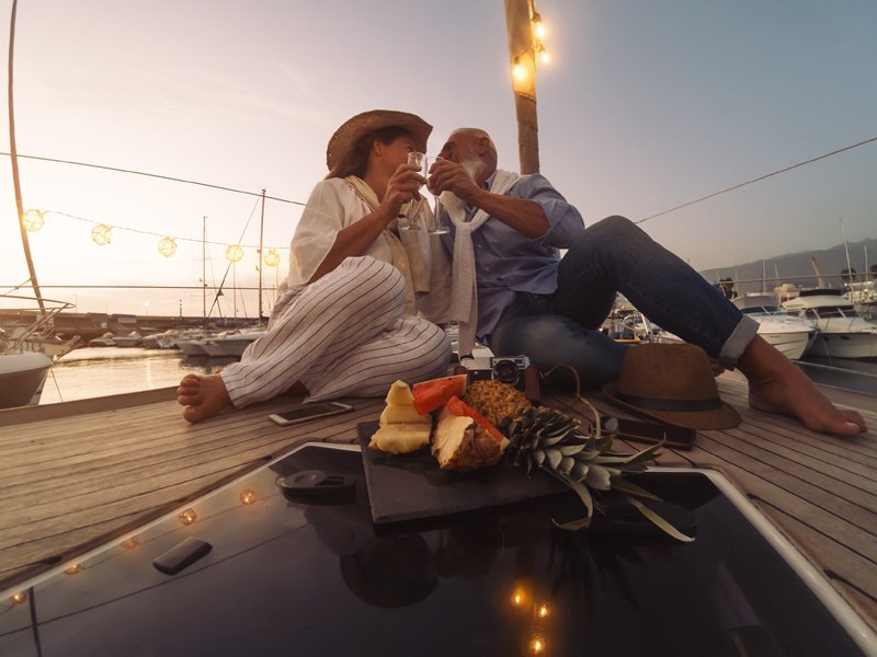 Senior Couple Toasting Champagne On Sailboat Vacation - Happy Ma